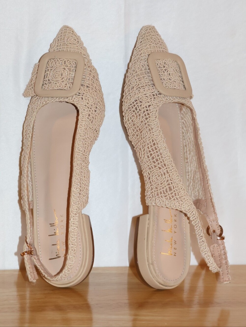 Nicole Miller Cream Malky Pointed-Toe Slingback Flats with Decorative Buckle.